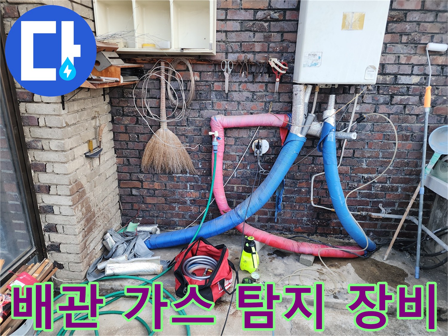 벽돌 벽면 아래 설치된 누수 탐지용 가스 호스와 작업 도구들