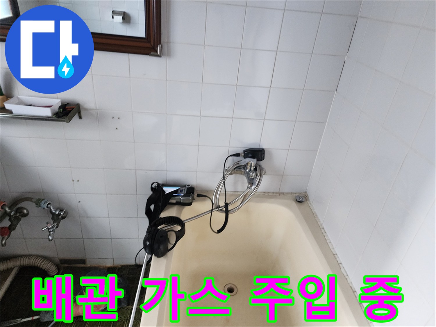 욕조 옆 벽면 배관에 누출 확인용 가스를 주입하는 작업 장면