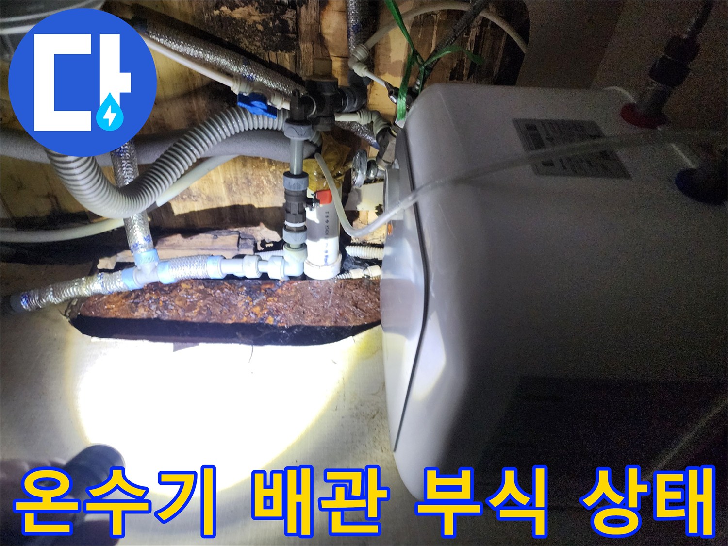 전기 온수기 하단 연결 부위의 심한 부식과 누수 흔적