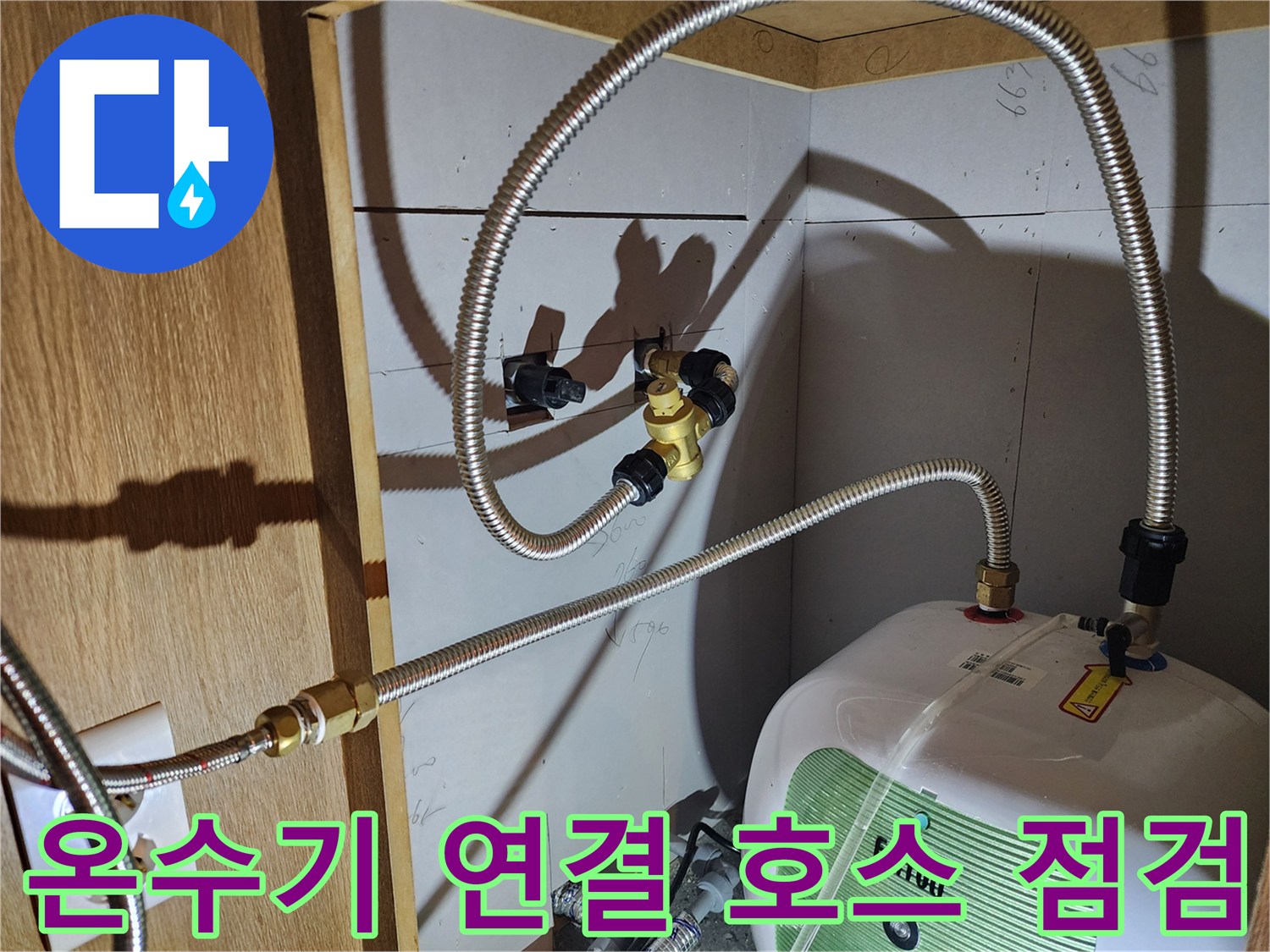 금속 재질의 유연한 배관과 전기 온수기 본체 결합 부위 근접 촬영