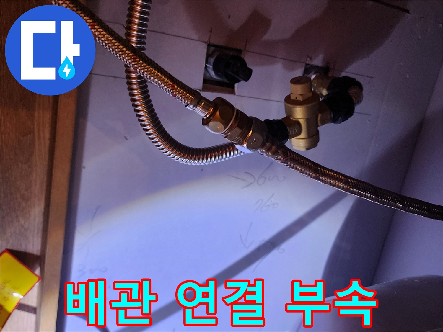 온수기와 연결된 금속 호스 및 황동색 연결 부품 상세 사진