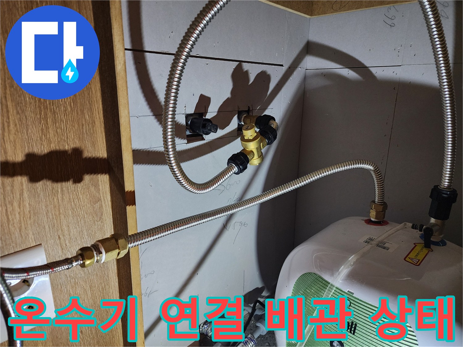 전기 온수기 하단-누수가 발생하는 금속 호스 접합부