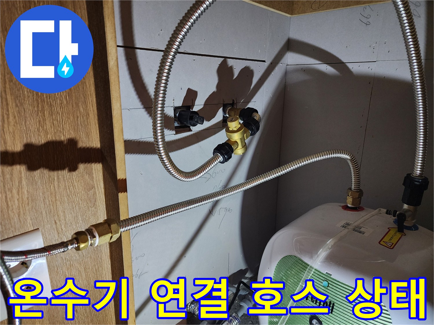 주방 하부장 내부-노후된 배관 부속과 호스 연결 모습