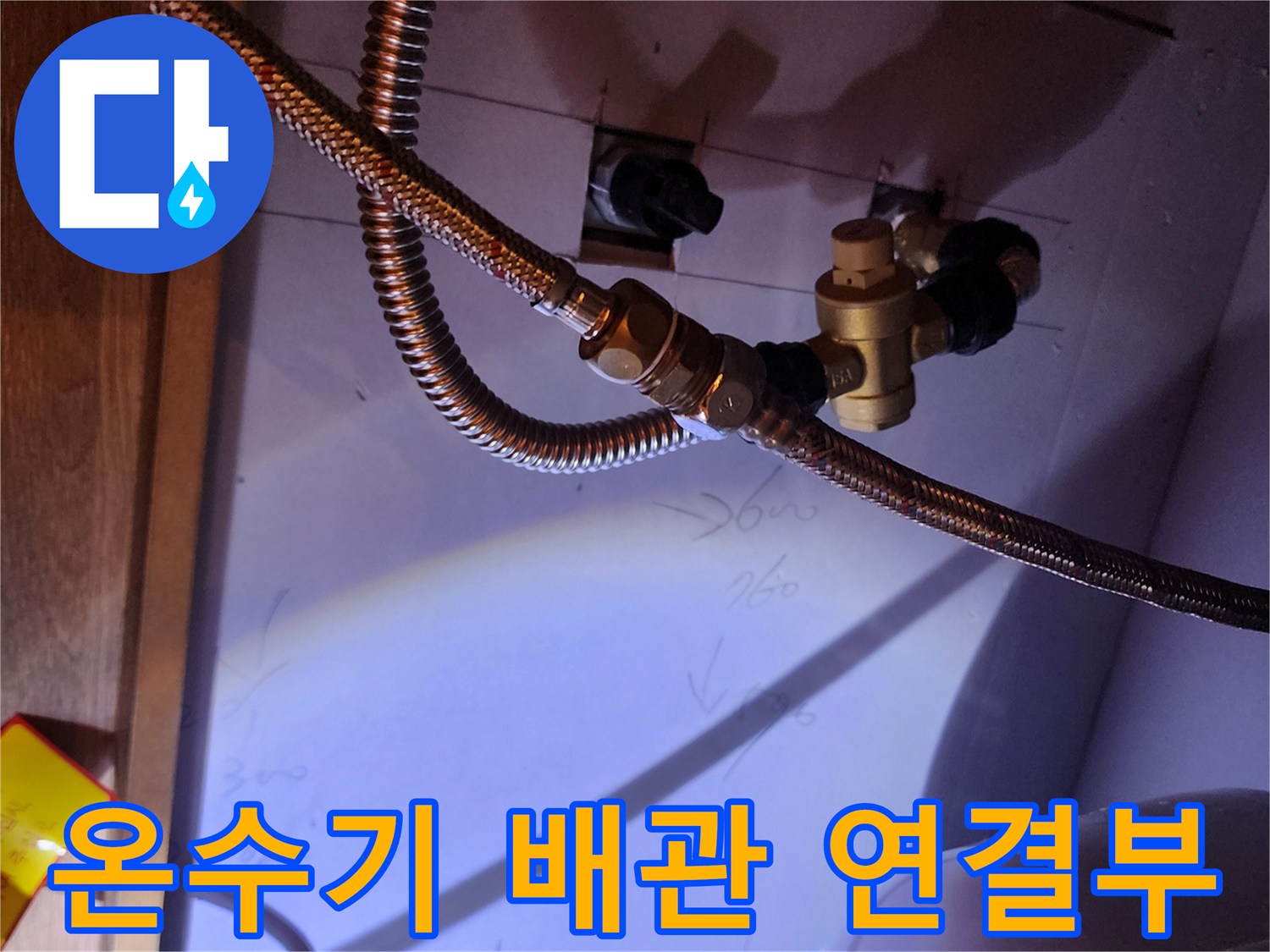 주방 하부장 전기 온수기와 연결된 금속 플렉시블 호스 상세 모습
