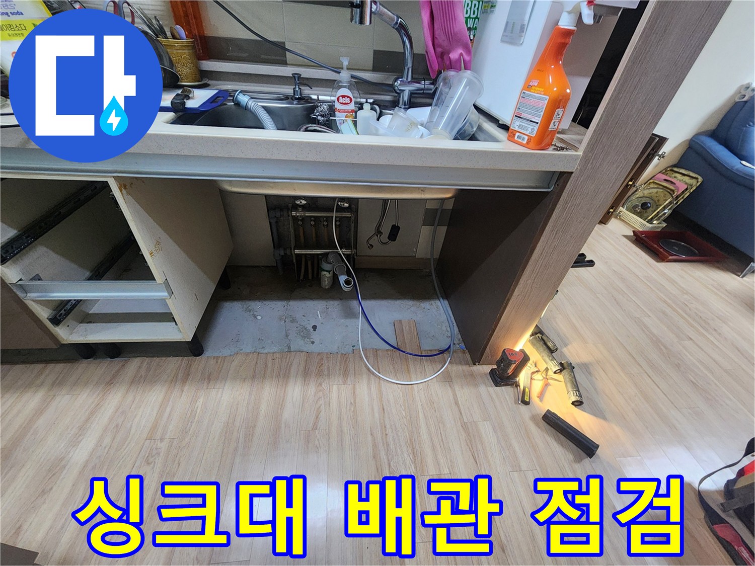 싱크대-아래-설치된-급수-및-배수-배관의-전체적인-상태를-종합적으로-점검하며-누수-징후를-찾는-모습