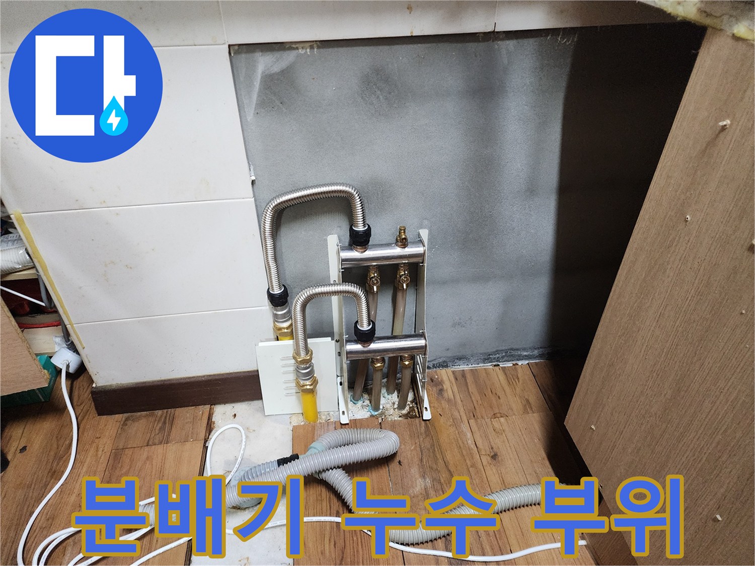 싱크대 하단의 은색 주름관과 분배기 밸브 연결 모습입니다.