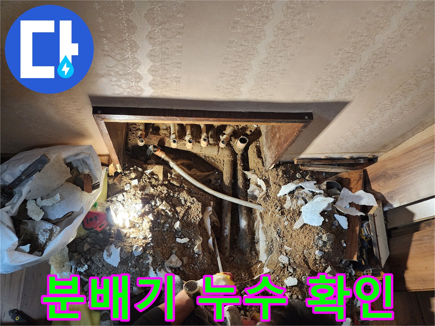 파헤쳐진 바닥 속 분배기 연결 부위와 젖은 배관