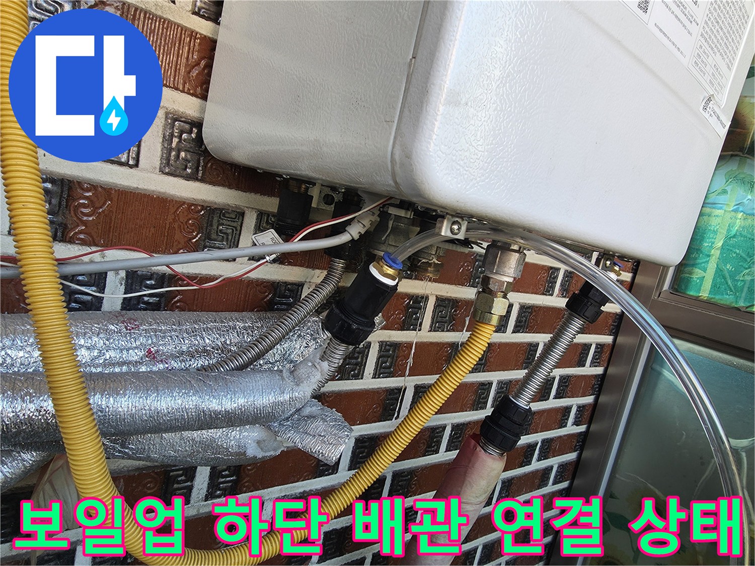 보일러 아래쪽의 노란색 호스와 금속 부품들 상세 사진
