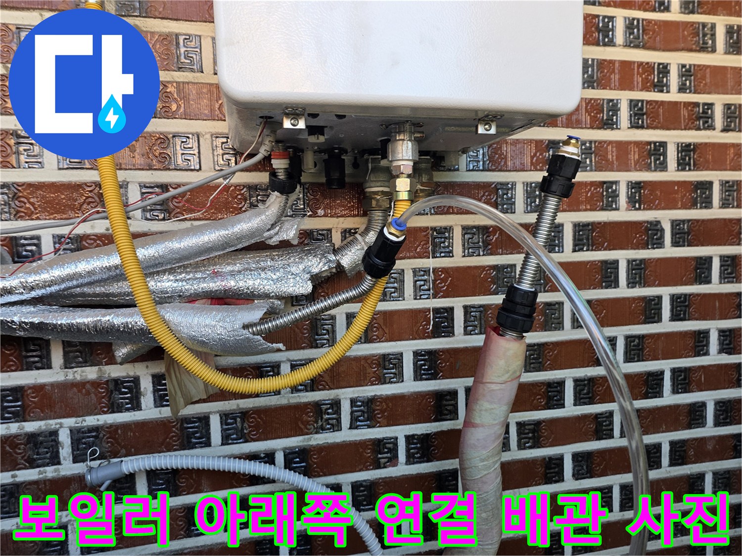 보일러 하단의 노란색 호스와 은색 보온 배관 상세