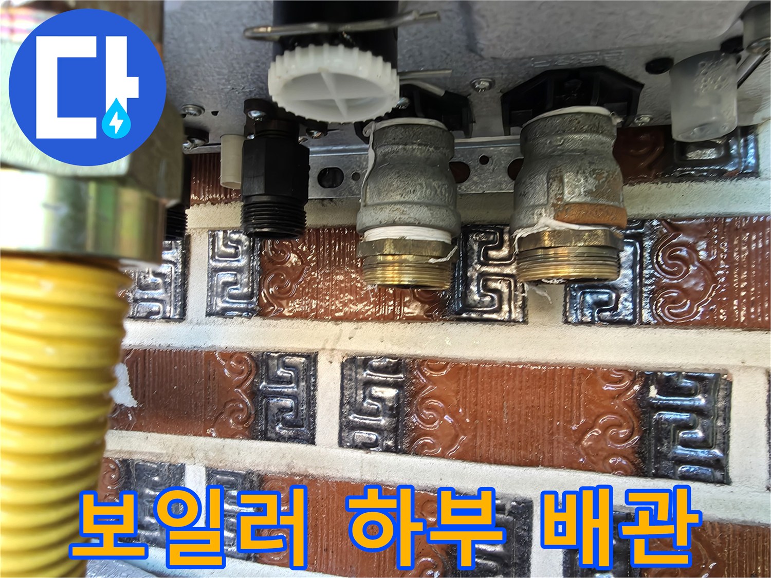 보일러 하부의 금속 연결 부품과 호스 사진