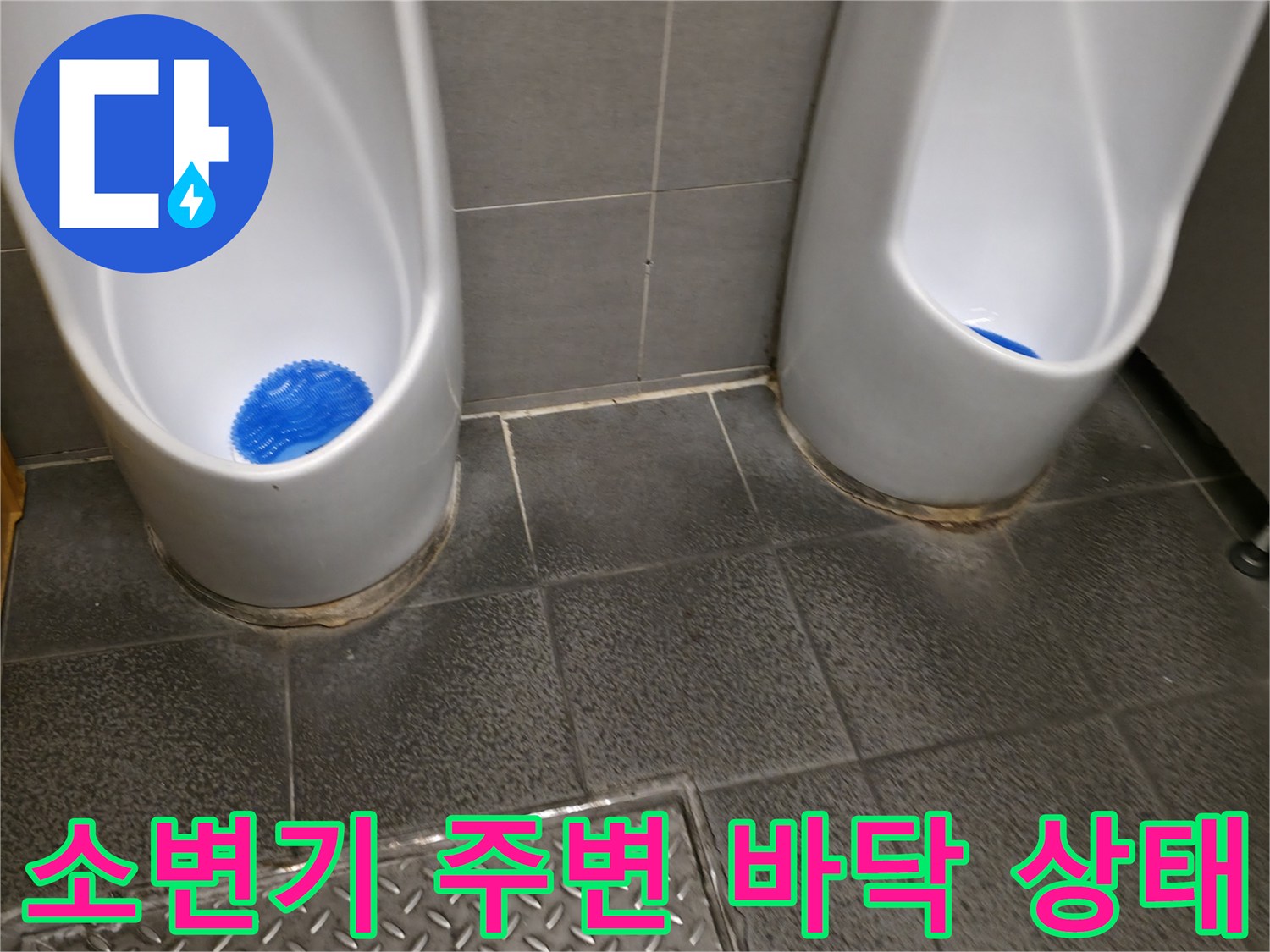 물기가 있는 소변기 하단 타일 부근의 근접 촬영 사진