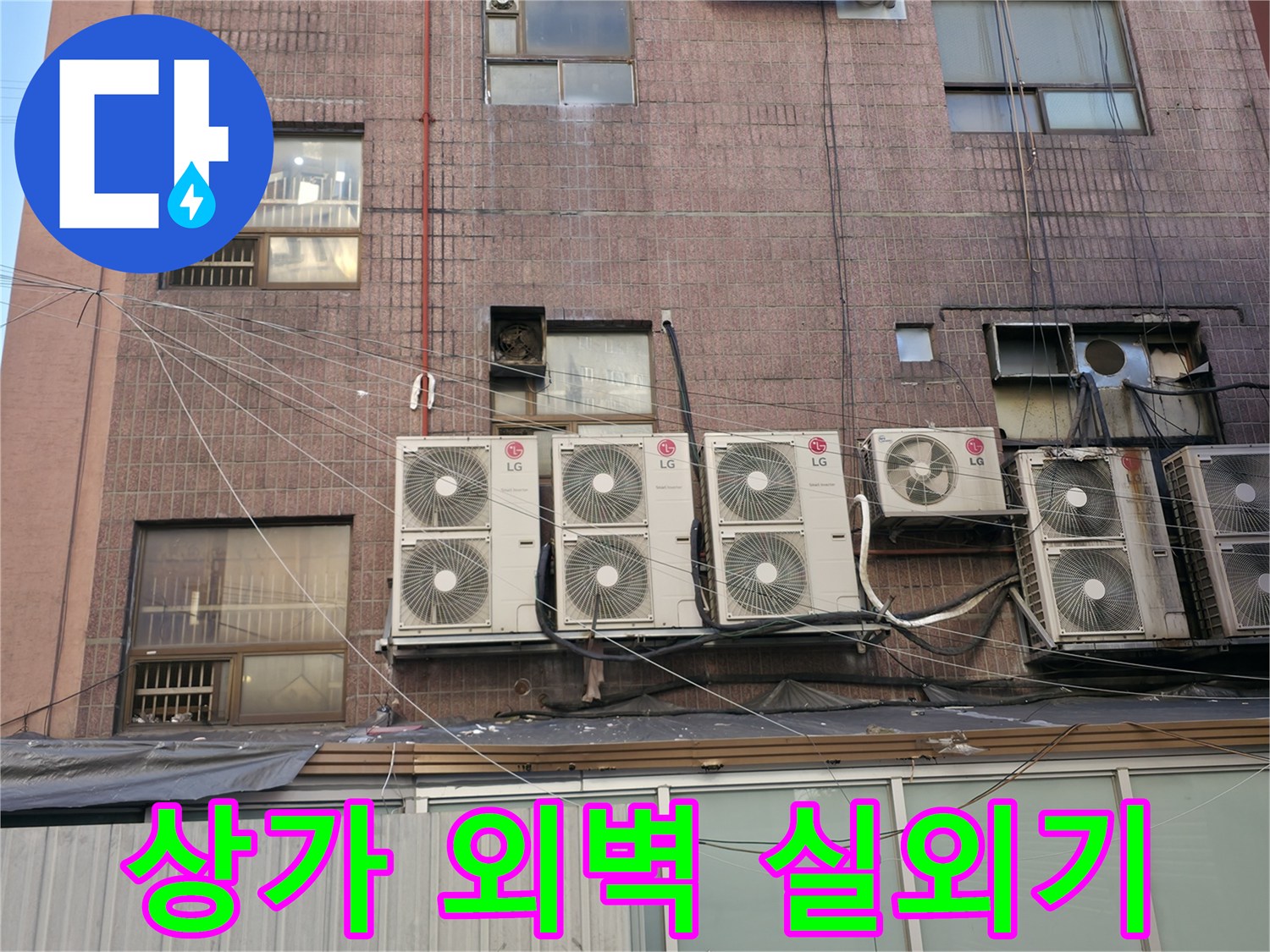 상가 건물 외벽에 설치된 에어컨 실외기와 노출된 배관들