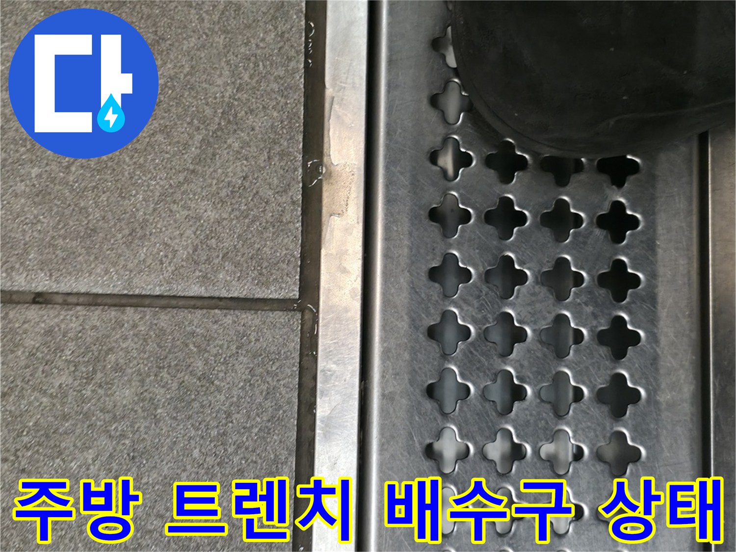 상가 주방의 스테인리스 배수 트렌치와 타일 바닥 모습