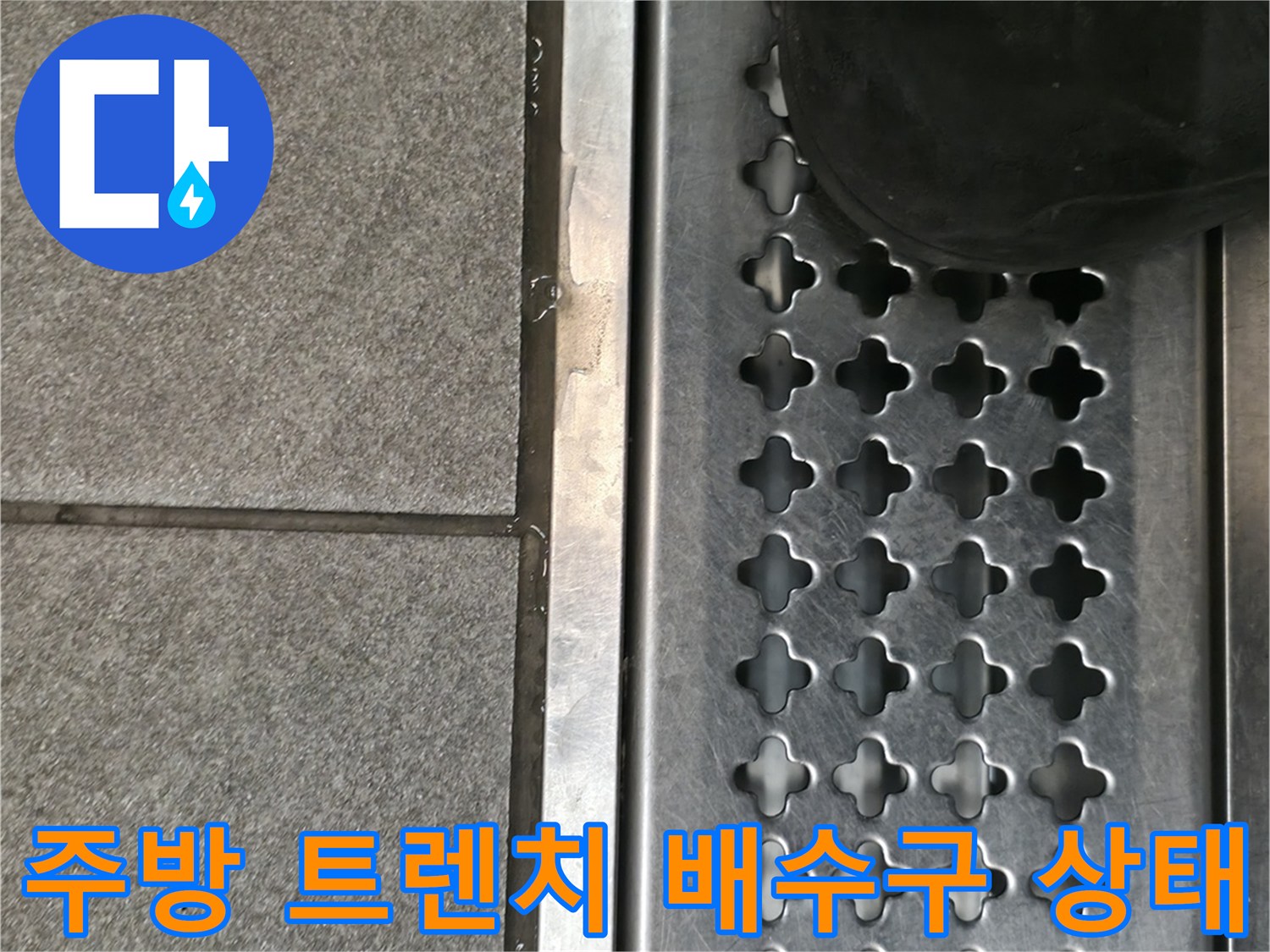 상가 주방의 스테인리스 트렌치 배수구와 바닥 타일 근접 사진