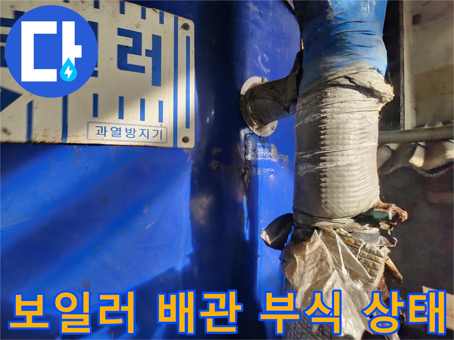파란색 보일러 본체와 연결된 배관의 부식된 모습입니다.