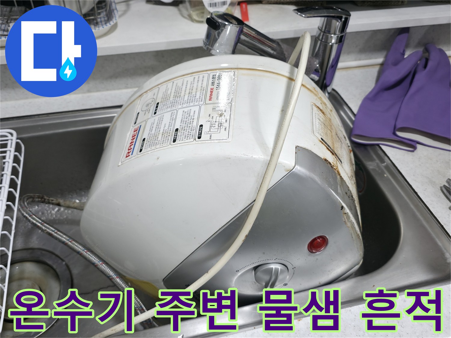 싱크대 아래 전기 온수기의 부식된 연결 부위와 녹물 자국