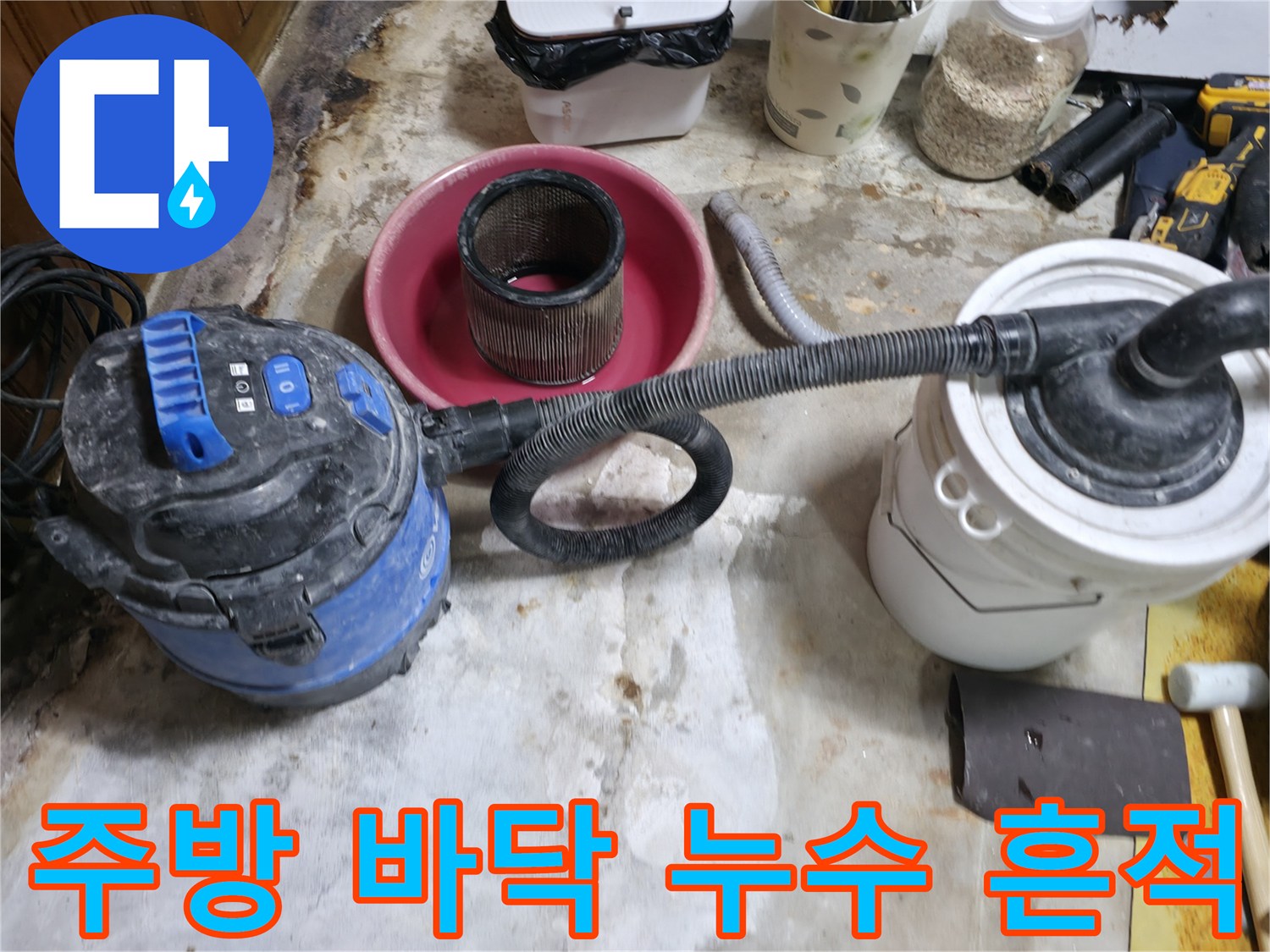 누수 공사 후 잔해물을 청소기로 정리하는 모습