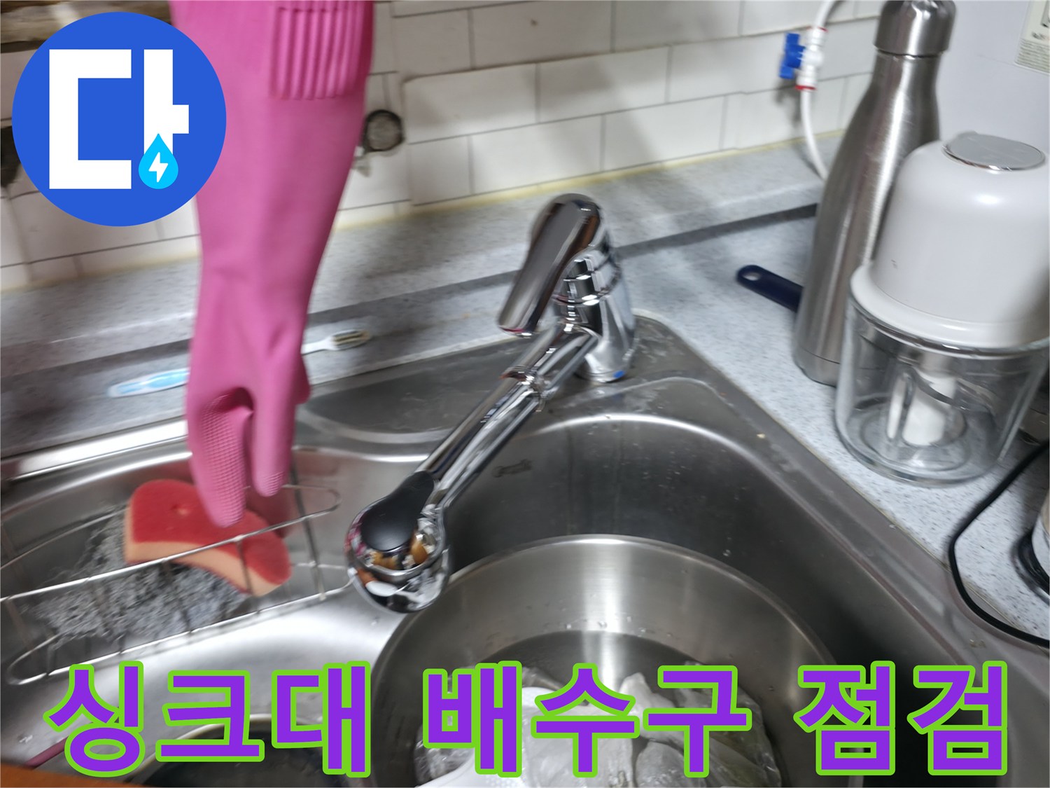 주방 싱크대 수전과 세척 도구가 놓인 작업 환경입니다.