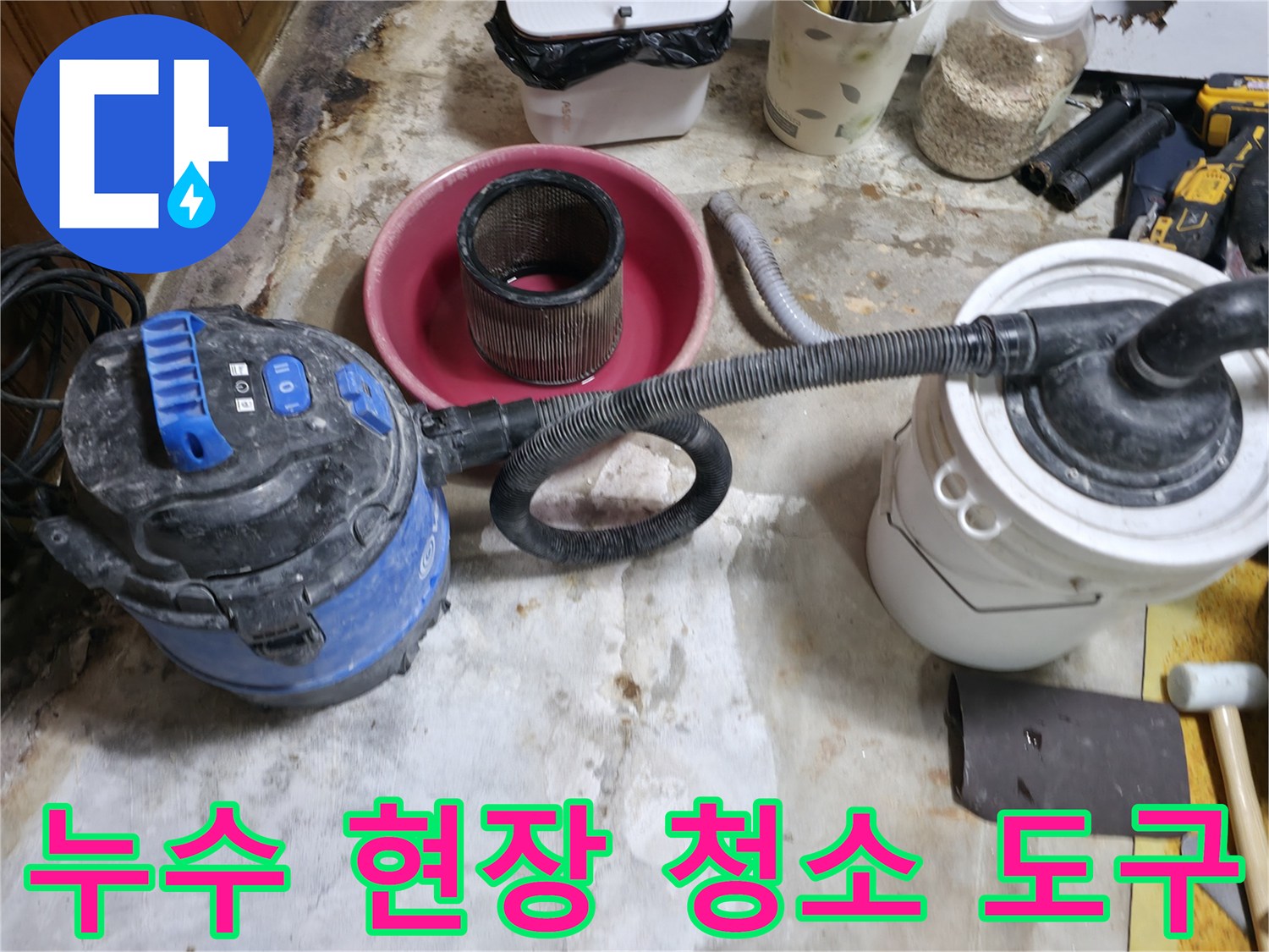 현장 바닥의 오염물질을 제거하기 위해 진공청소기를 사용하는 모습입니다.