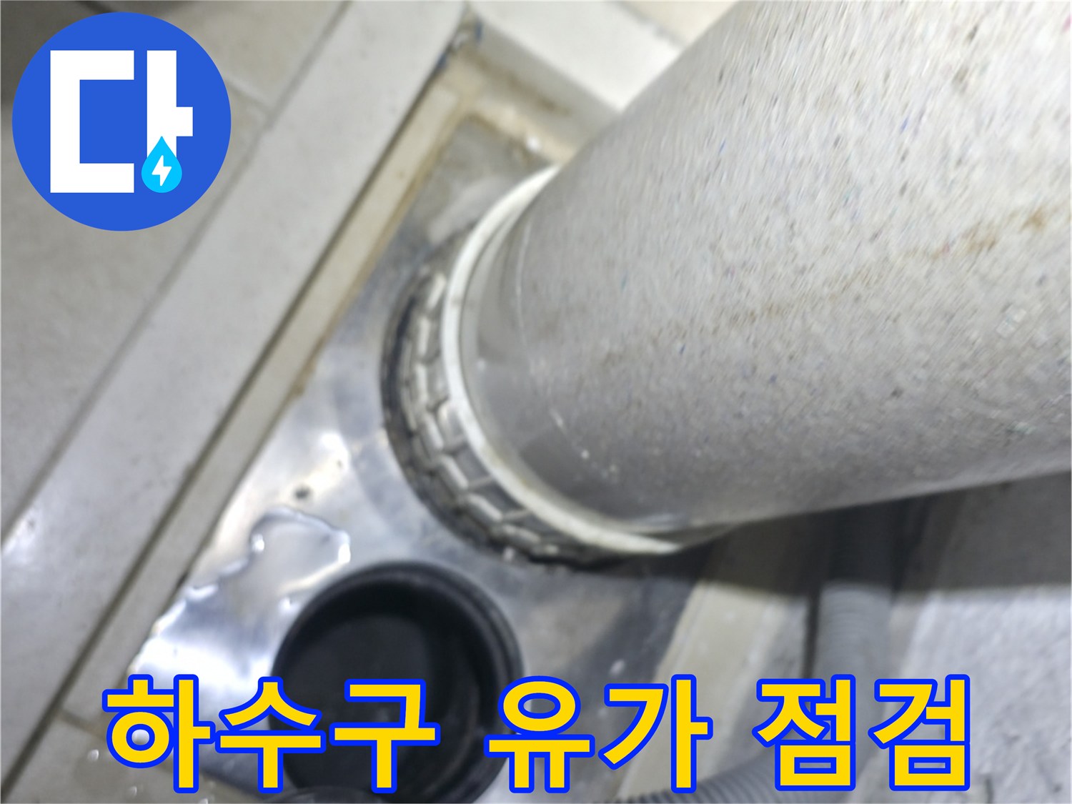 물기가 고여 있는 세탁실 바닥 배수구 근접 촬영