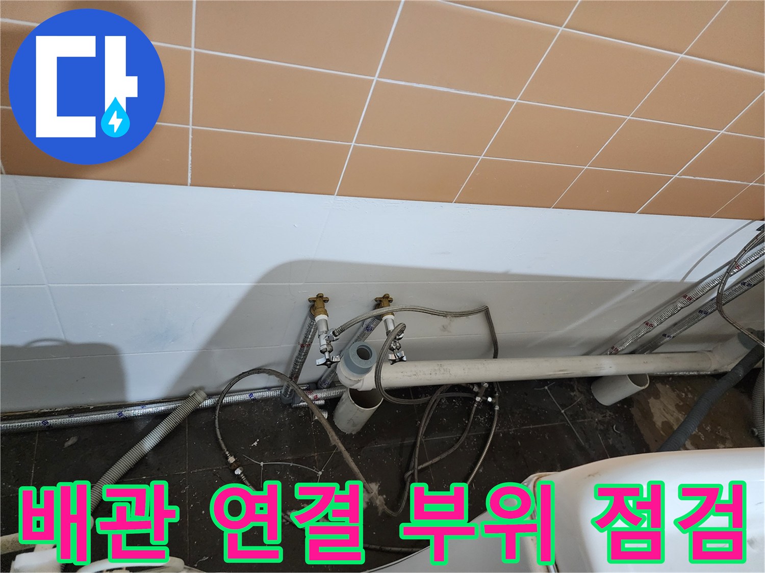 벽면 타일 아래 배관 조인트와 지지대 근접 촬영