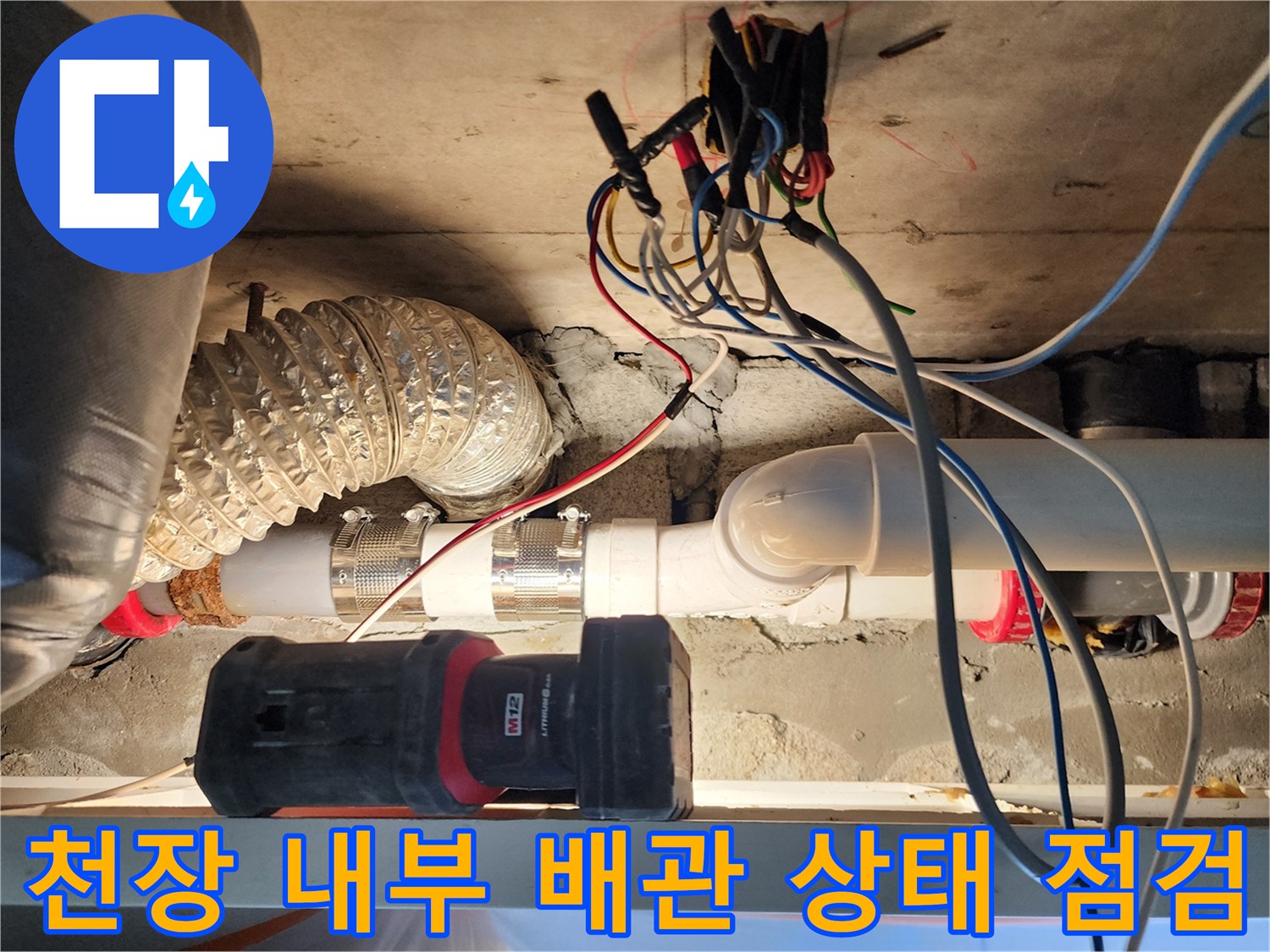 복잡한 배선과 은색 단열재 사이의 하수 배관 구조