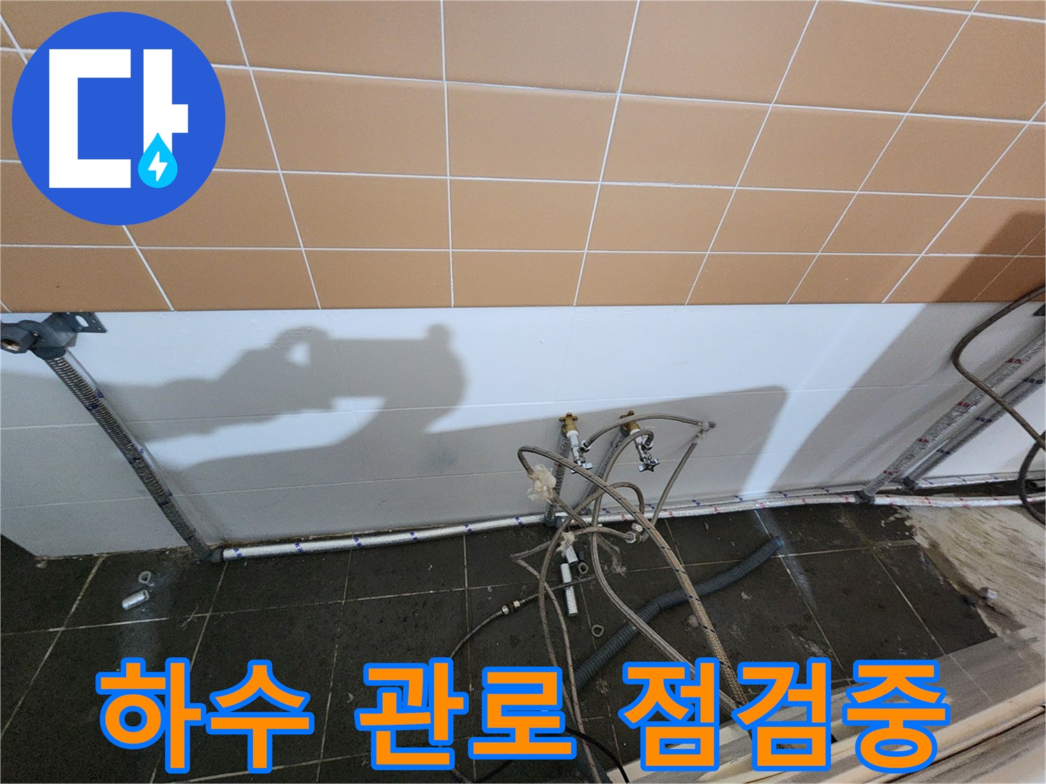 샴푸대 아래 복잡하게 얽힌 배관들의 연결 부위를 촬영하였습니다.