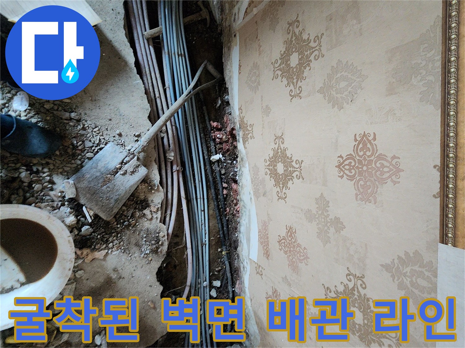 벽면 하단 흙과 함께 드러난 매립 배관의 모습-