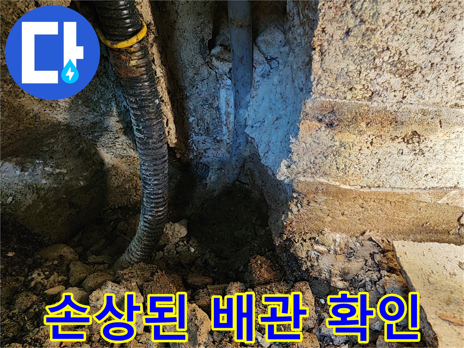 틈새로 보이는 파손된 배관과 젖은 토양