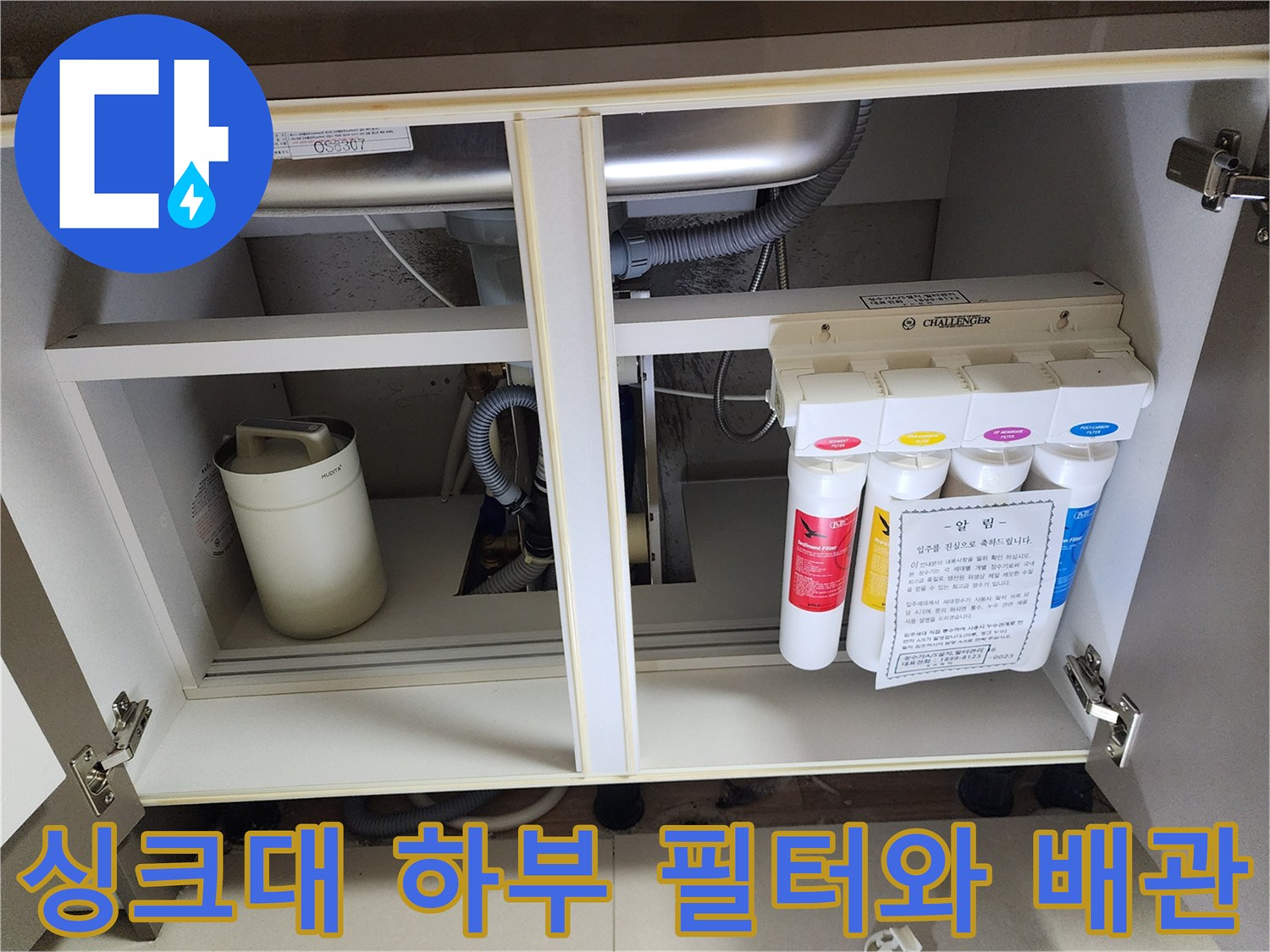싱크대 아래 정수기 필터 유닛과 연결된 굵은 배수 호스