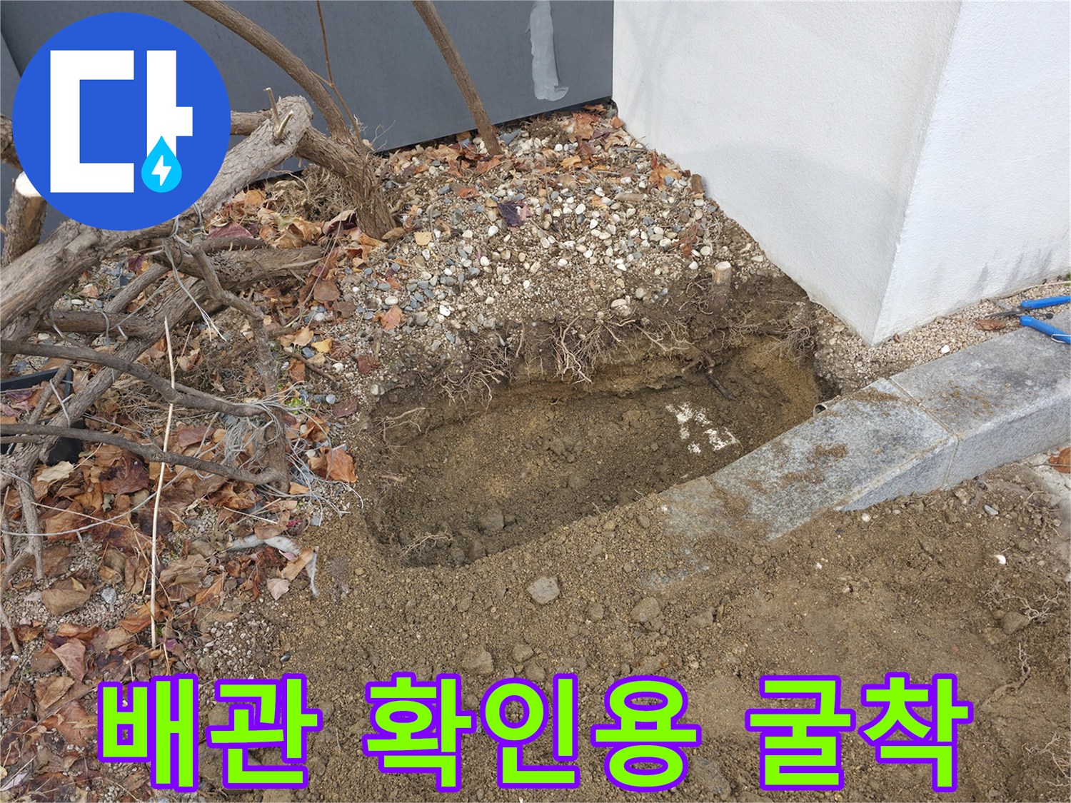 건물 외벽 옆-배관 점검을 위해 흙을 파낸 모습