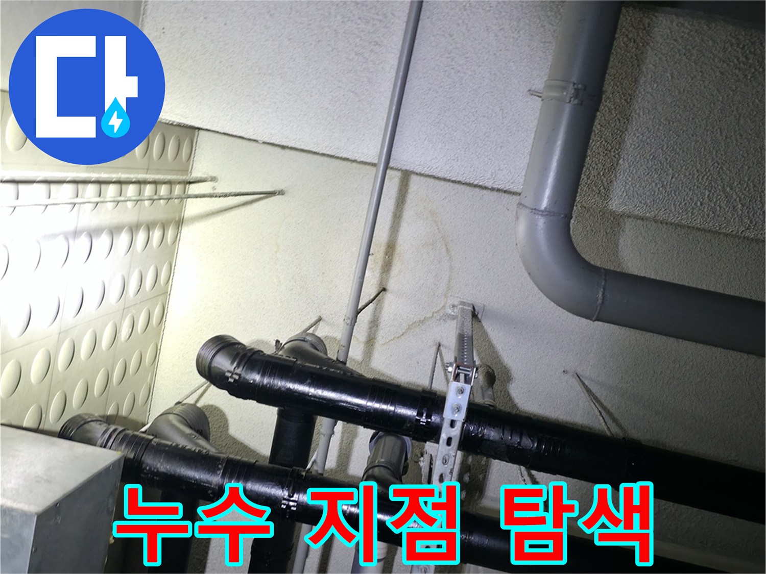 천장 내부-검은색 배관과 은색 고정 장치