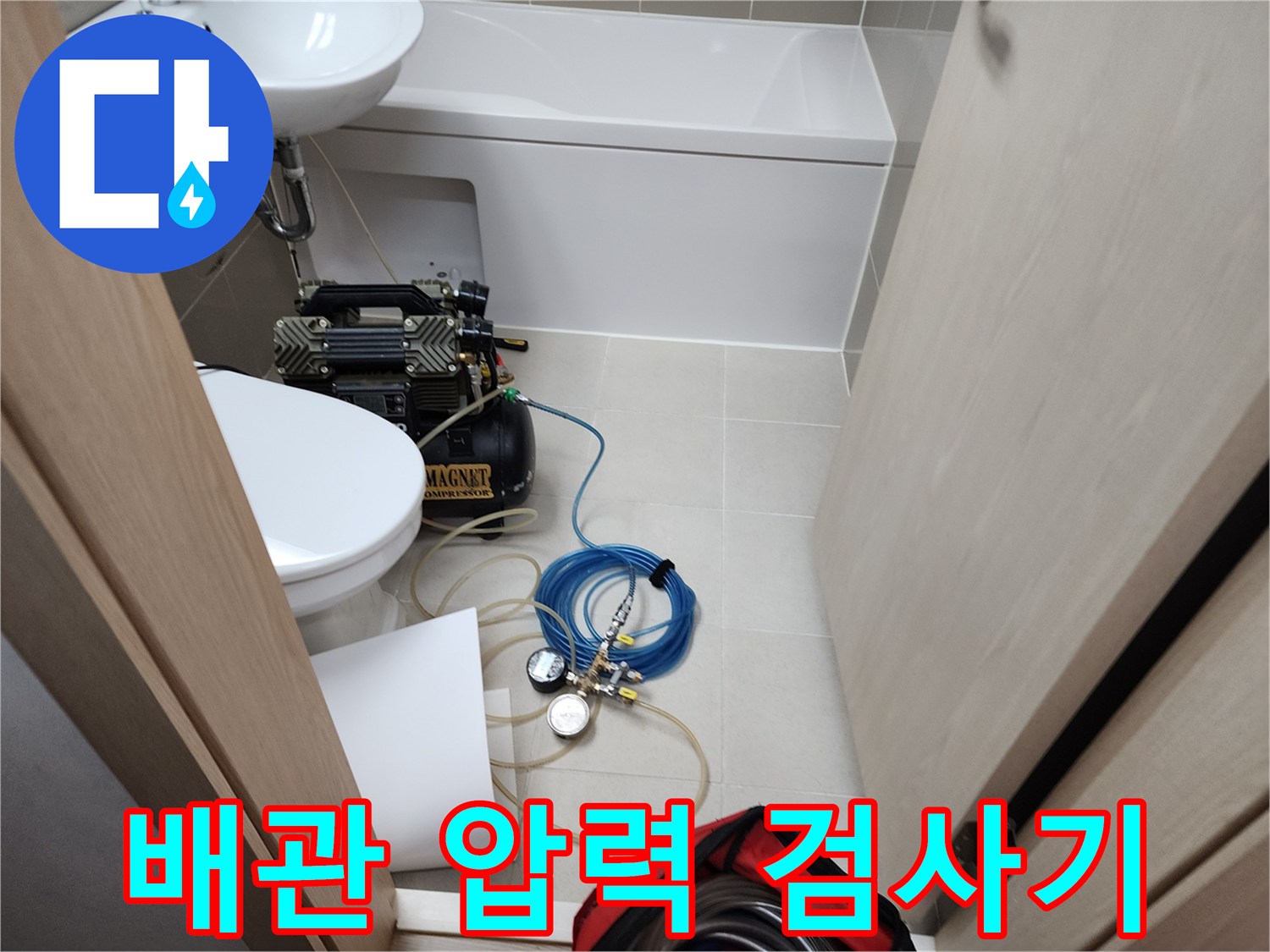 욕실 바닥에 배치된 콤프레샤와 연결된 파란색 에어 호스