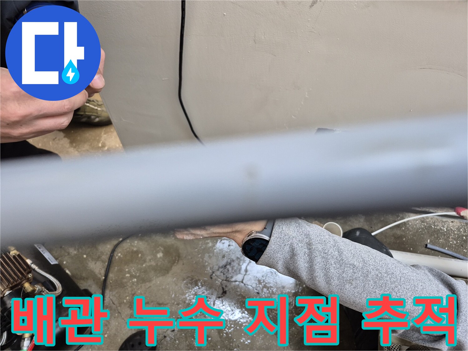 회색 배관의 연결 구간을 면밀하게 관찰하며 작업 중입니다.