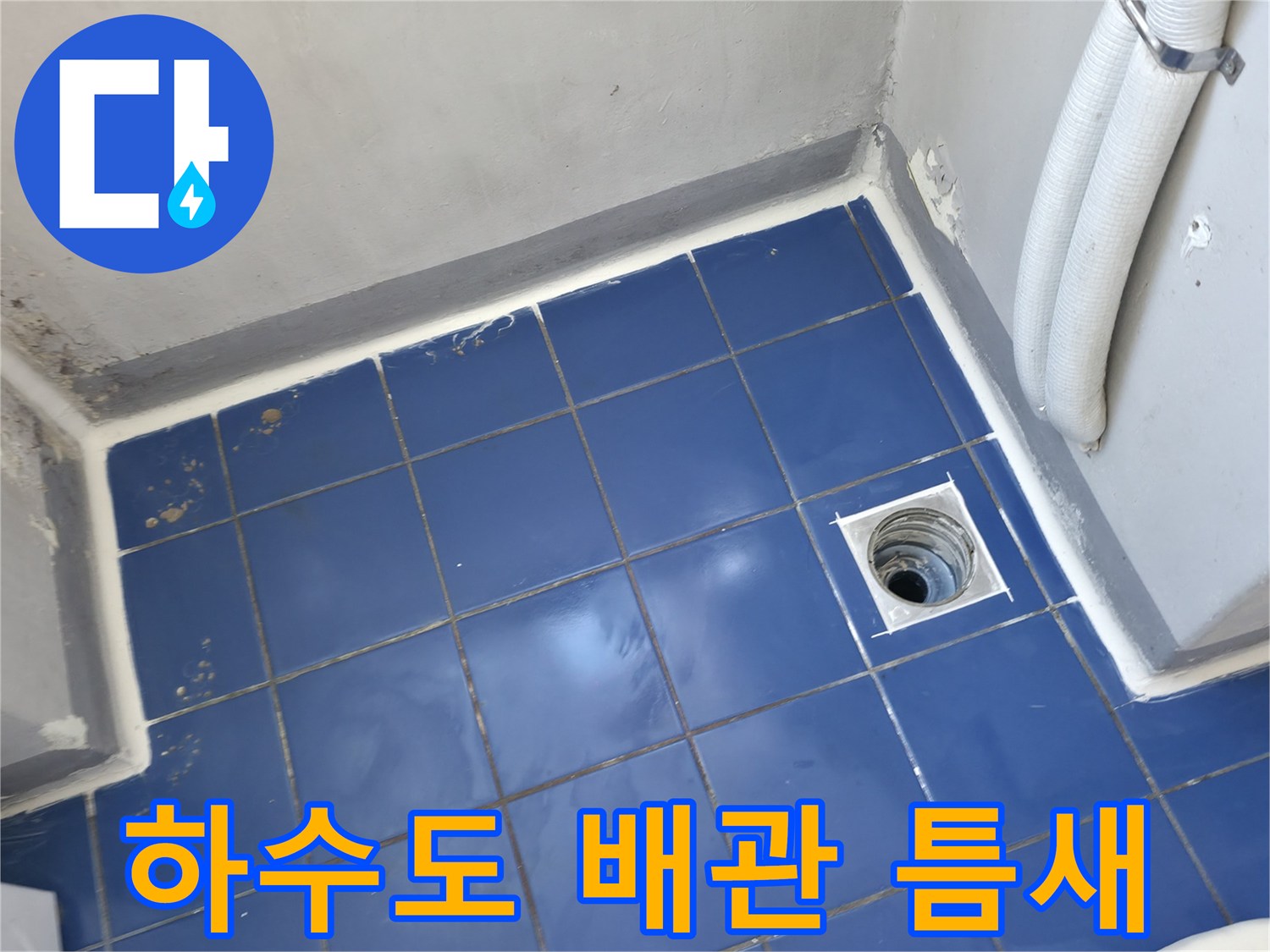 세탁실 바닥-배수구 주변 타일 균열 및 배관 노출 사진