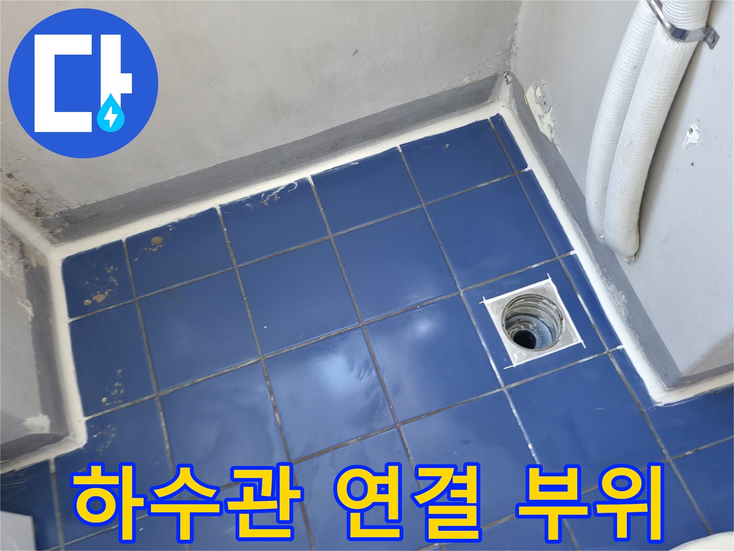 세탁실 하수구 배관과 타일 바닥의 접합부 근접 촬영