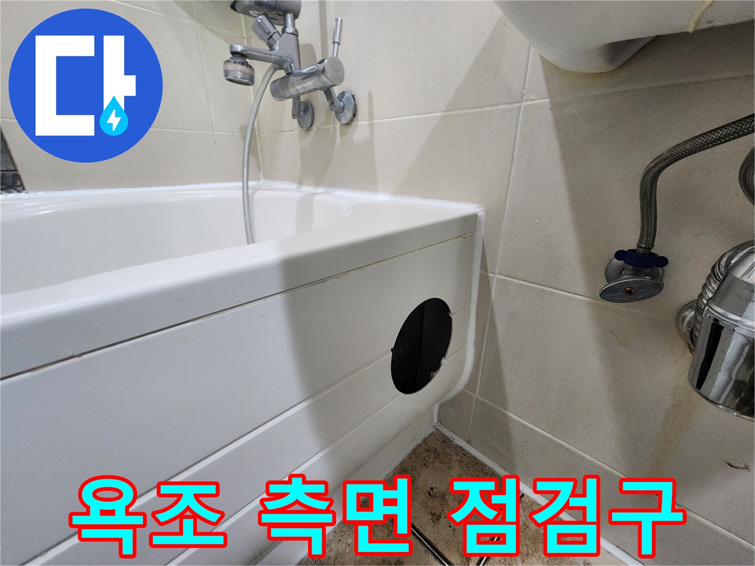 욕조 옆면의 검은색 점검구와 샤워 수전의 모습입니다.