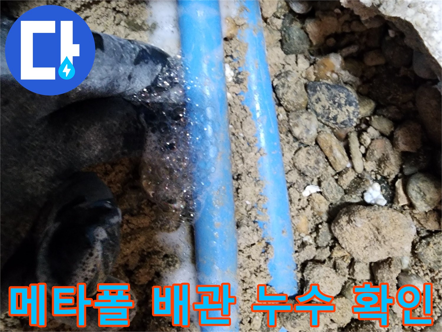 현장 사진-흙더미 사이로 보이는 파란색 배관 결함
