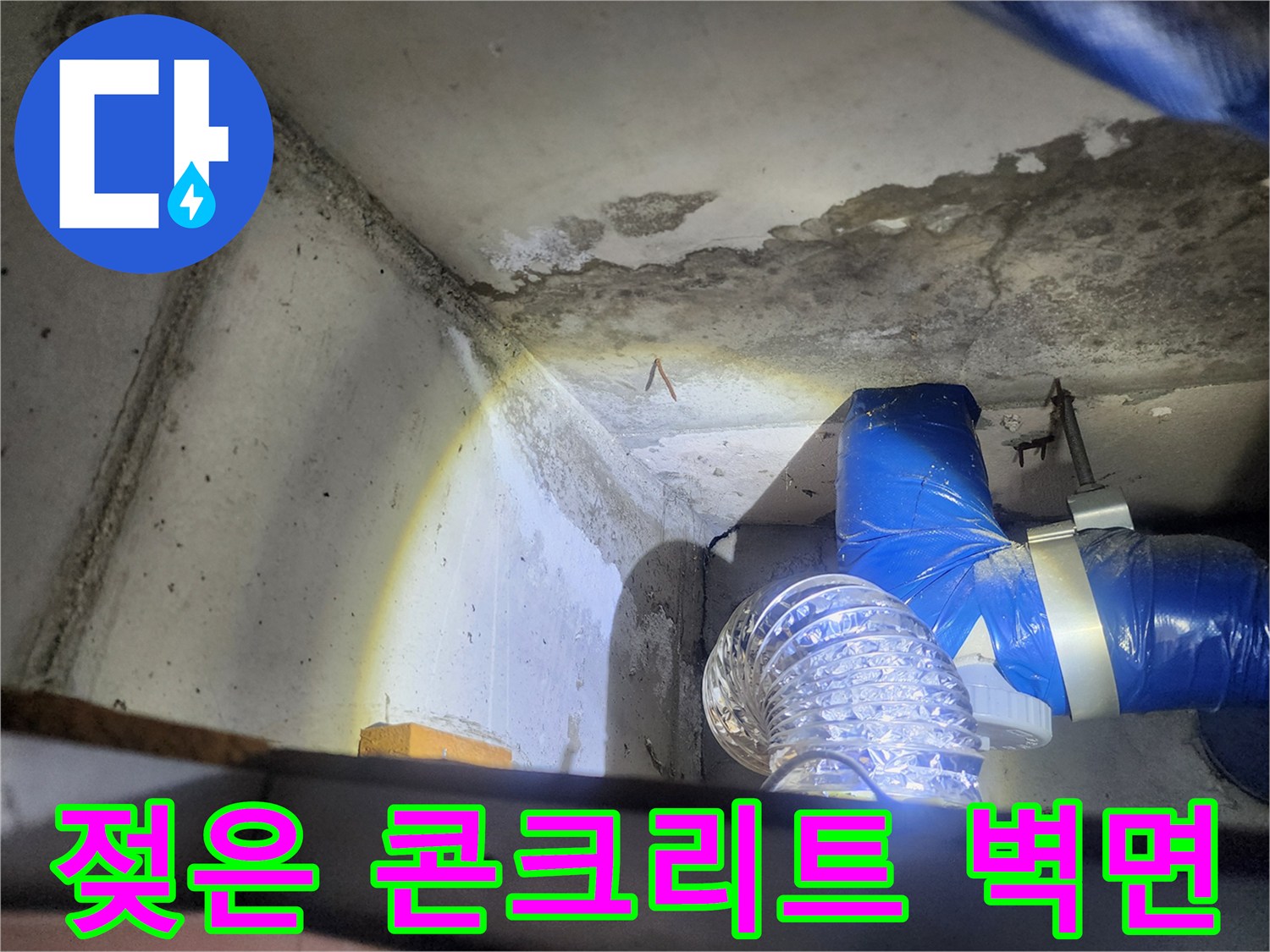 누수로 인해 변색된 천장 콘크리트와 파란 배관