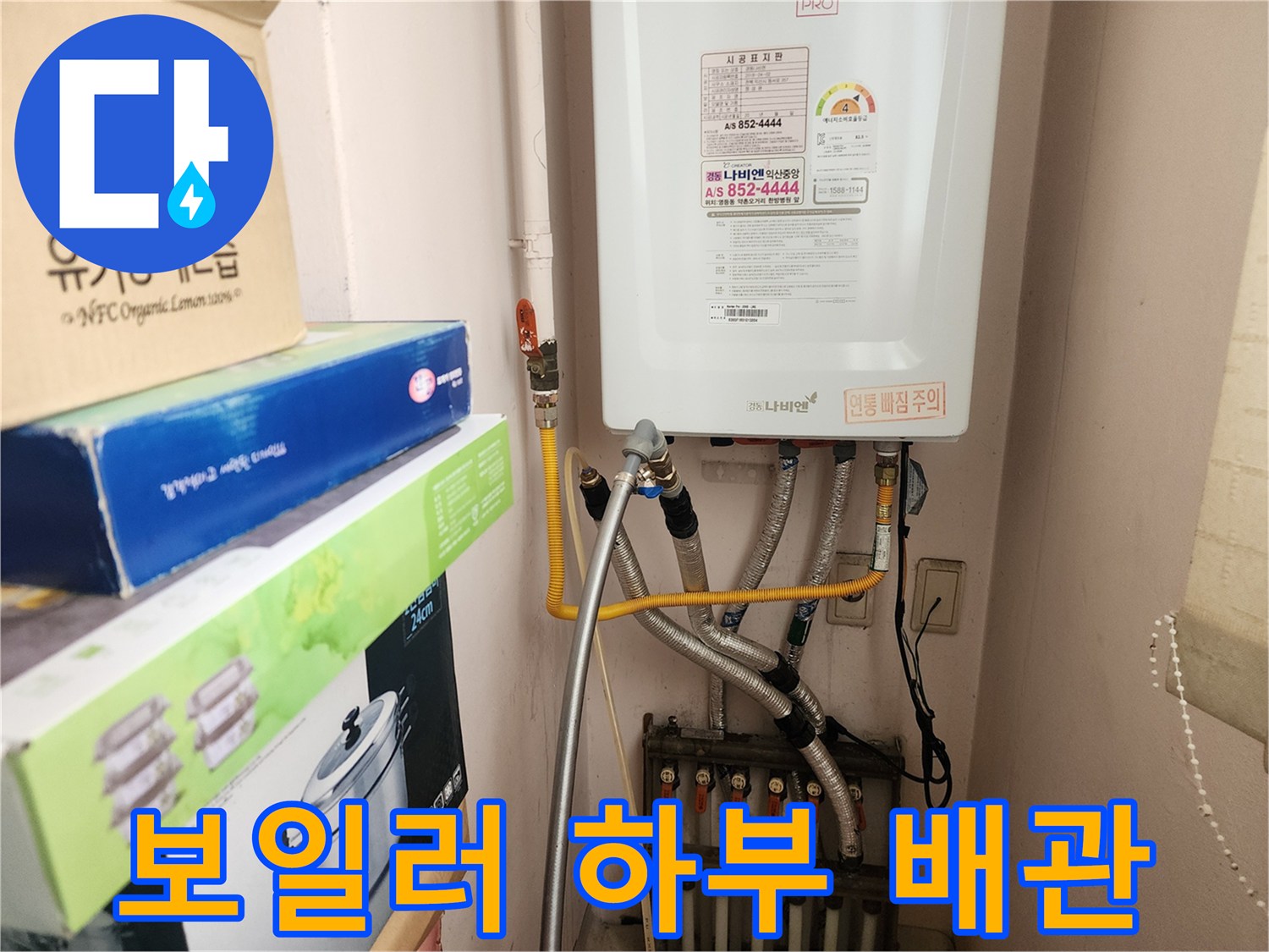 보일러 밑에 연결된 금속 및 플라스틱 배관들