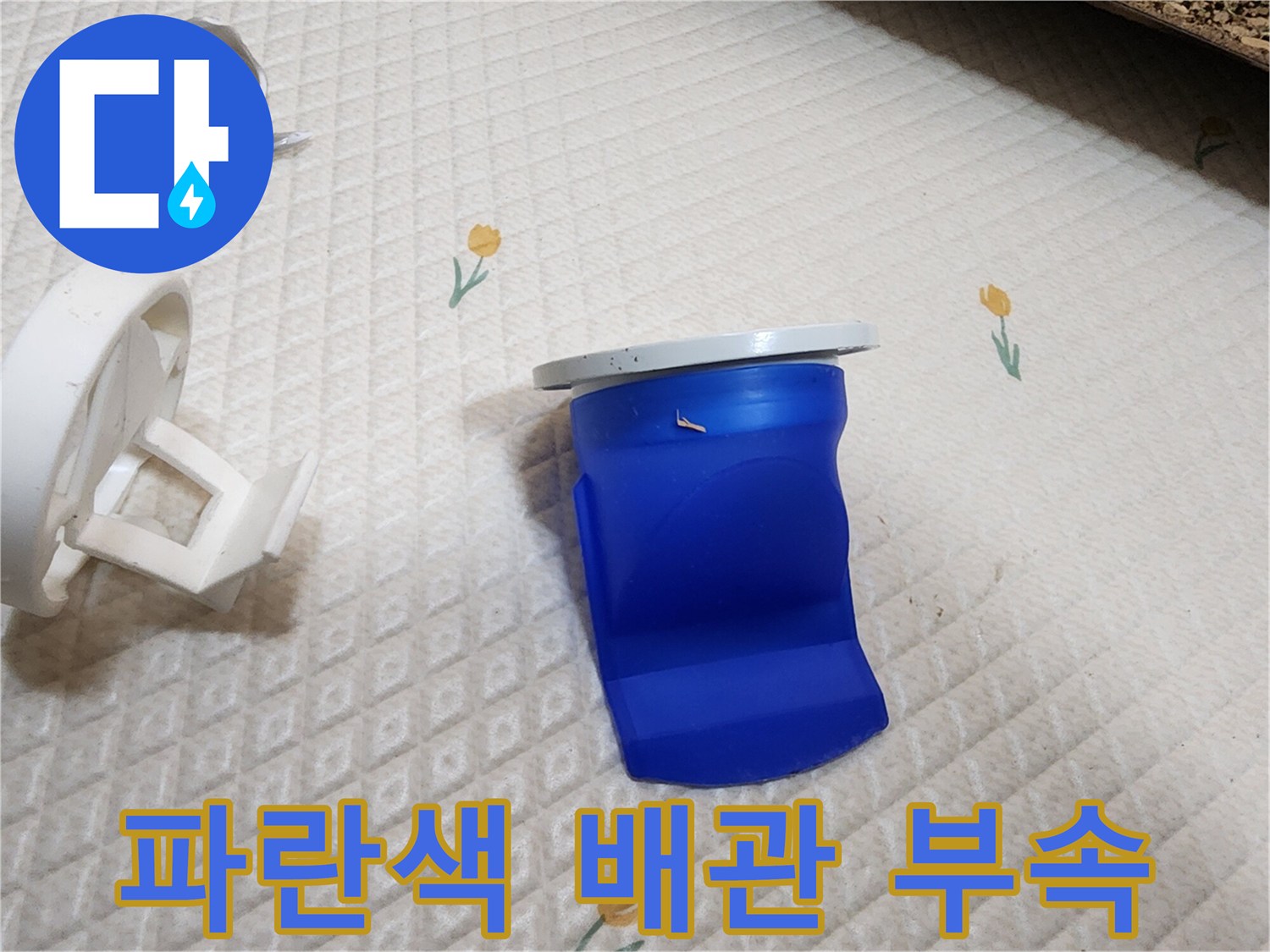 변기 하부의 파란색 플라스틱 배관 연결 부품