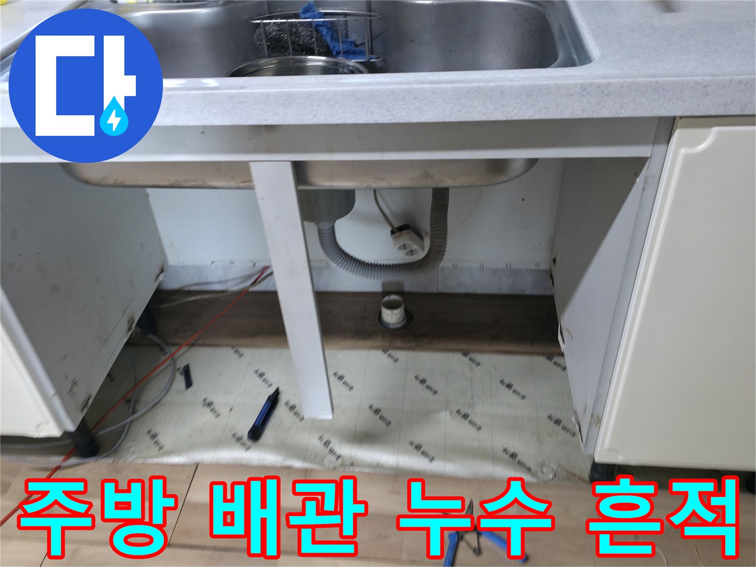싱크대 아래쪽의 젖은 바닥과 배관 연결 부위