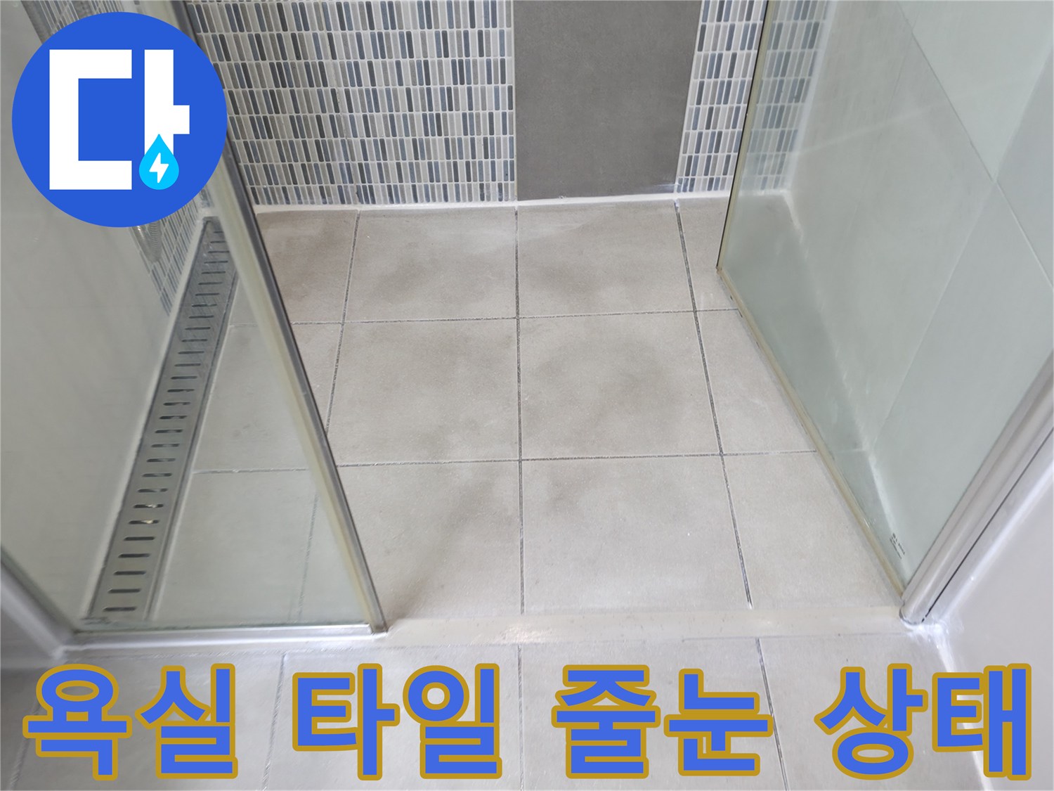 샤워기-사용 공간의 바닥 타일과 벽면 패턴 타일의 접합부 모습입니다.