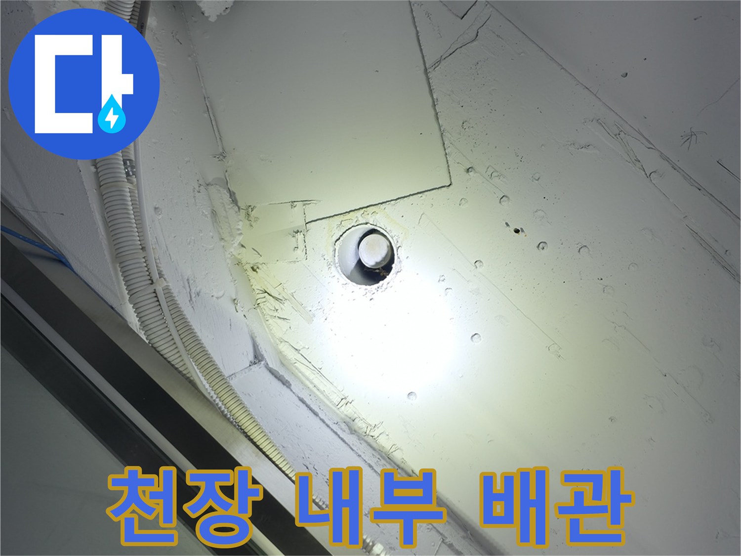 하얀색 천장 판넬과 연결된 급수 및 전기 배관