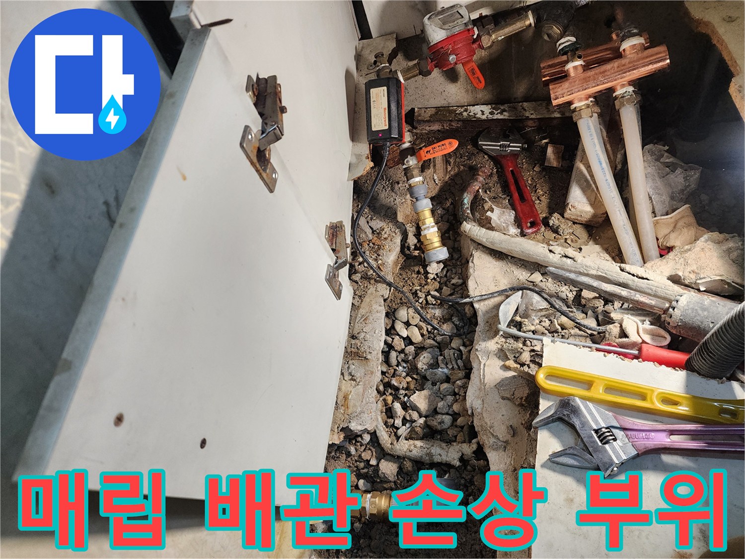 싱크대 하단 굴착 부위에 노출된 수도 배관과 공구들