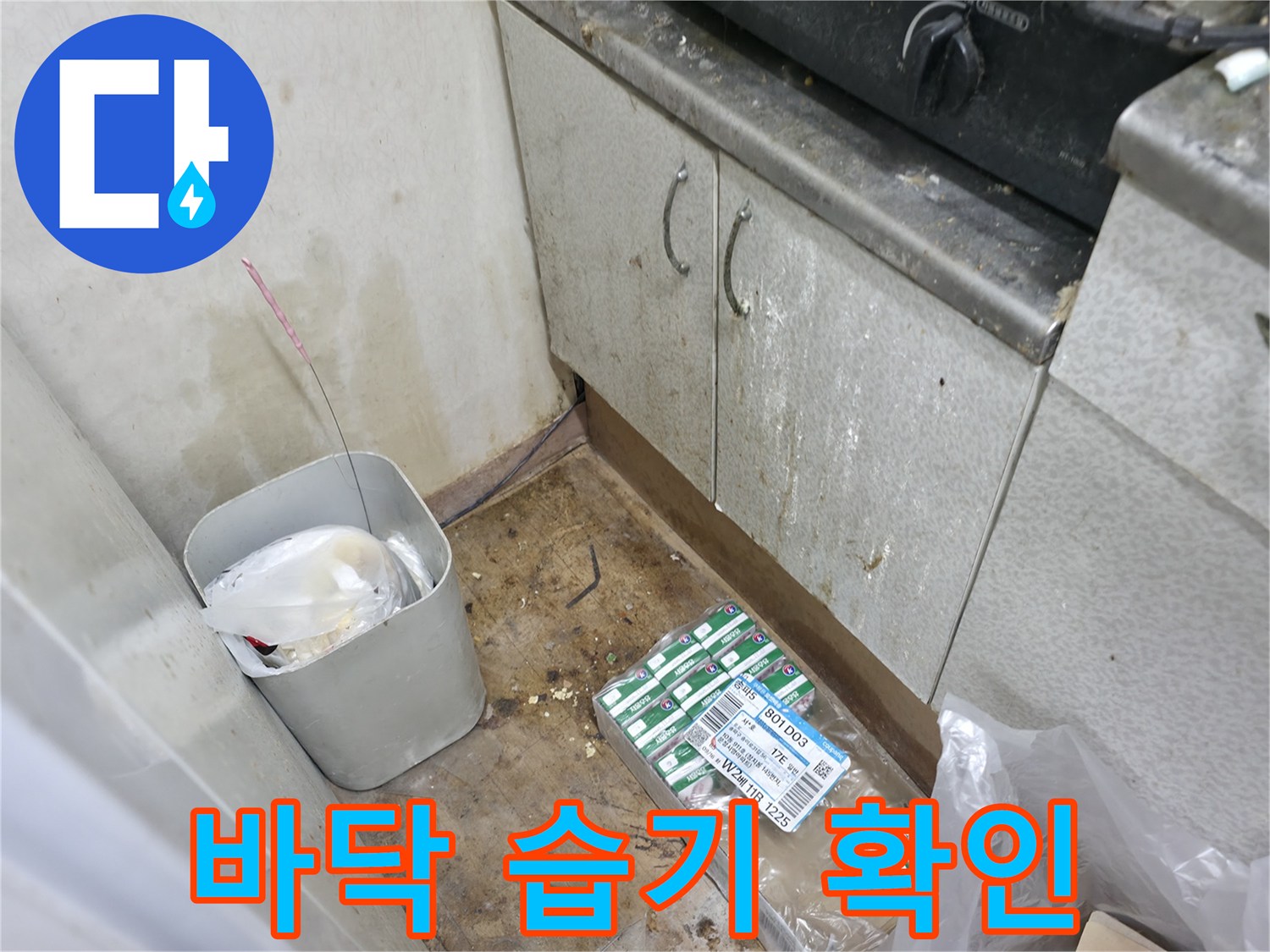 축축하게 젖은 싱크대 하부 바닥과 자재 상자