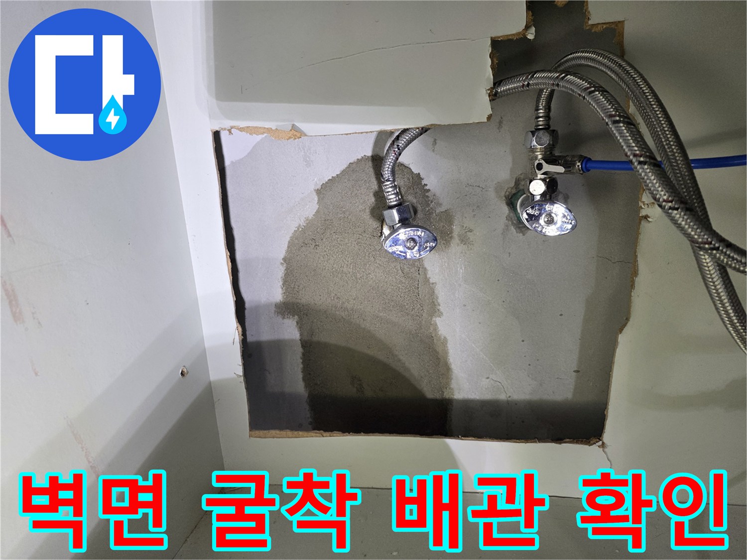 싱크대 아래 벽을 파내어 드러낸 노후 배관과 습기 흔적
