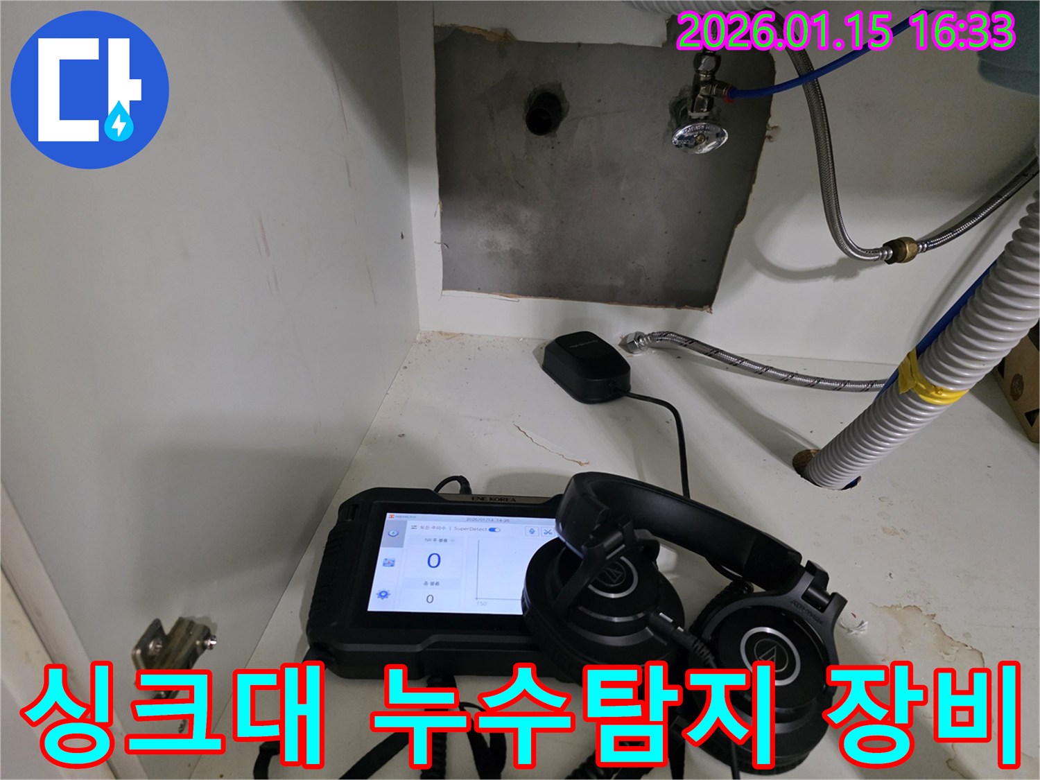 싱크대 하부에서 누수 지점을 찾기 위해 전문 탐지 장비를 사용하고 있습니다.