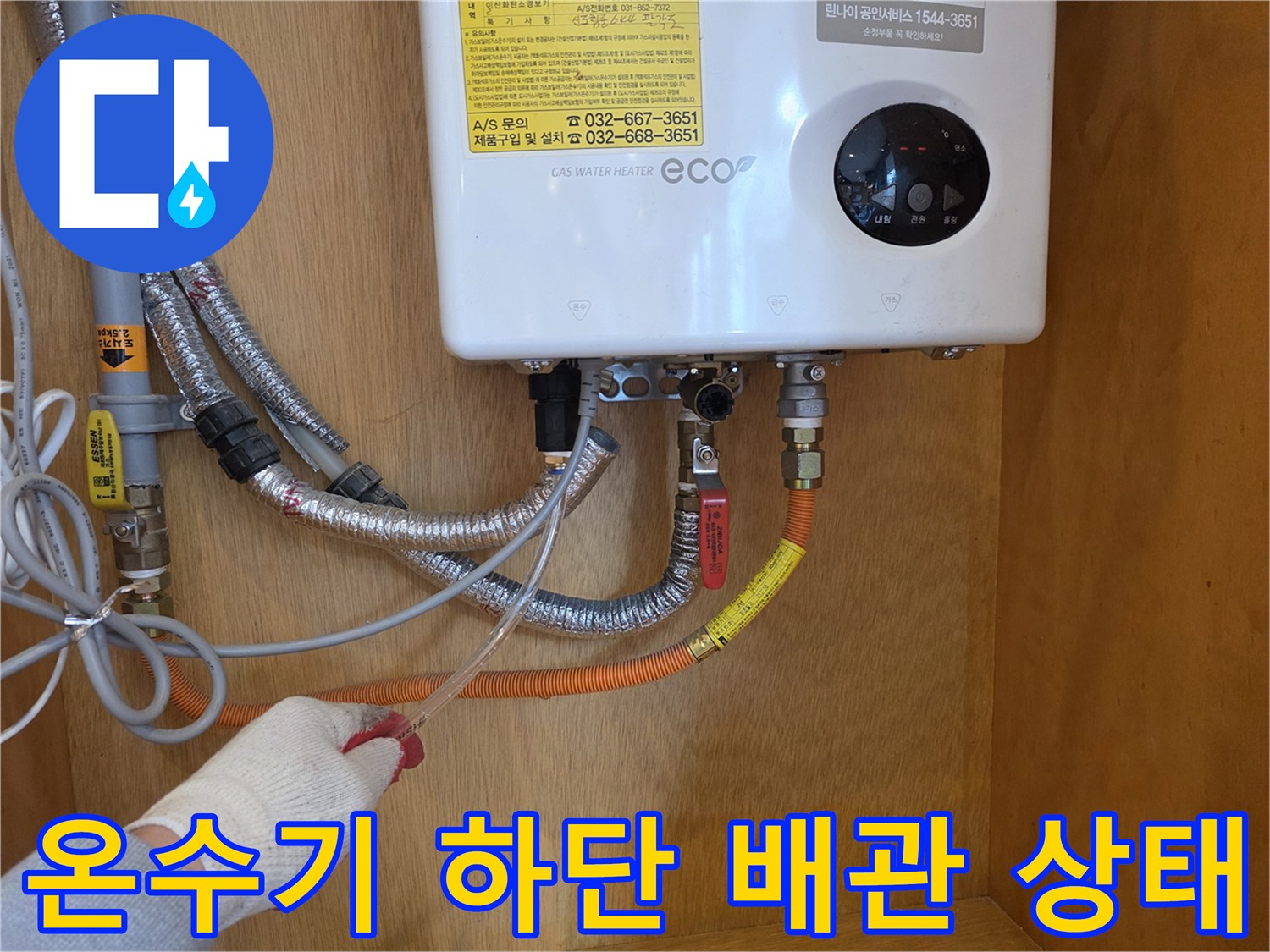 가스 온수기 하단에 연결된 금속 플렉시블 배관과 밸브 모습
