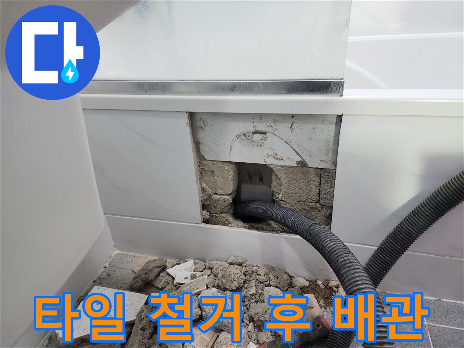 타일을 제거한 자리에 보이는 파손된 검은색 배관